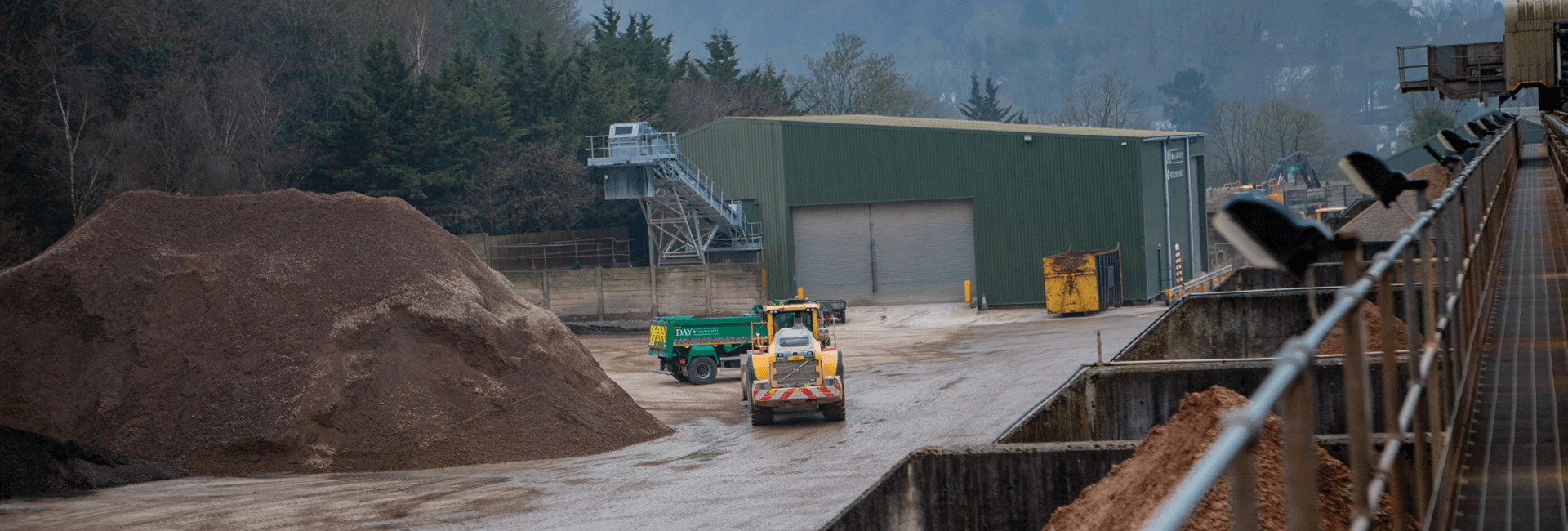 Aggregate site wide shot, with green Day Aggregates lorry and a yellow loading shovel