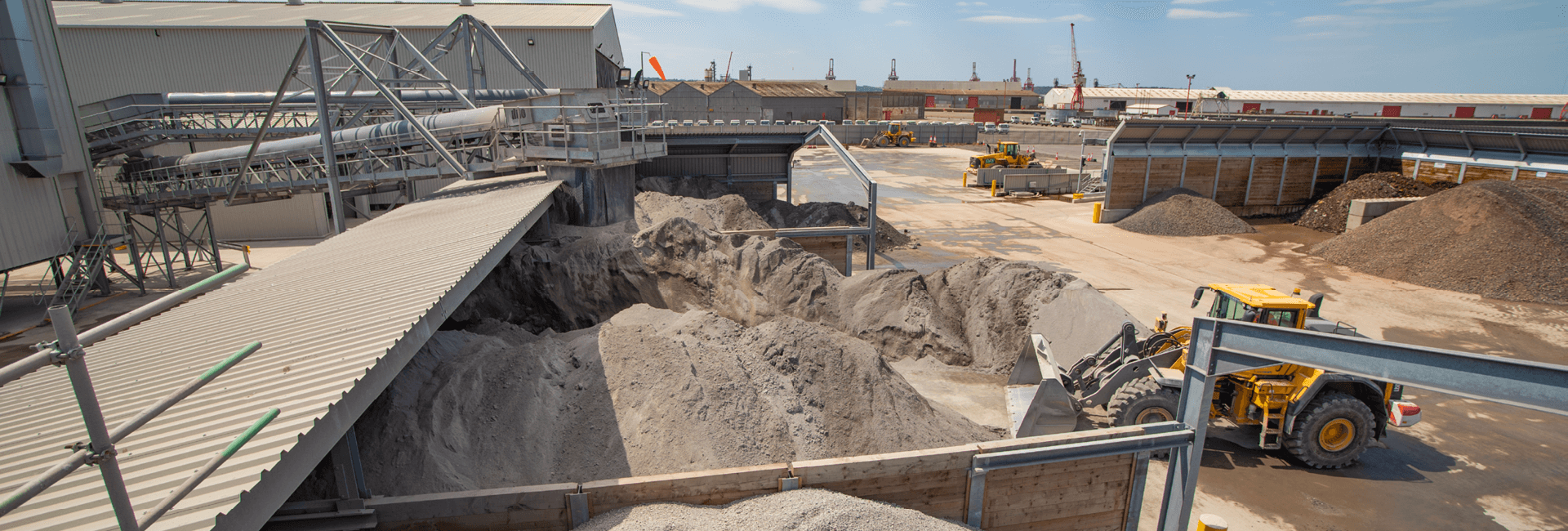 Piles of IBA with a and a loading shovel moving