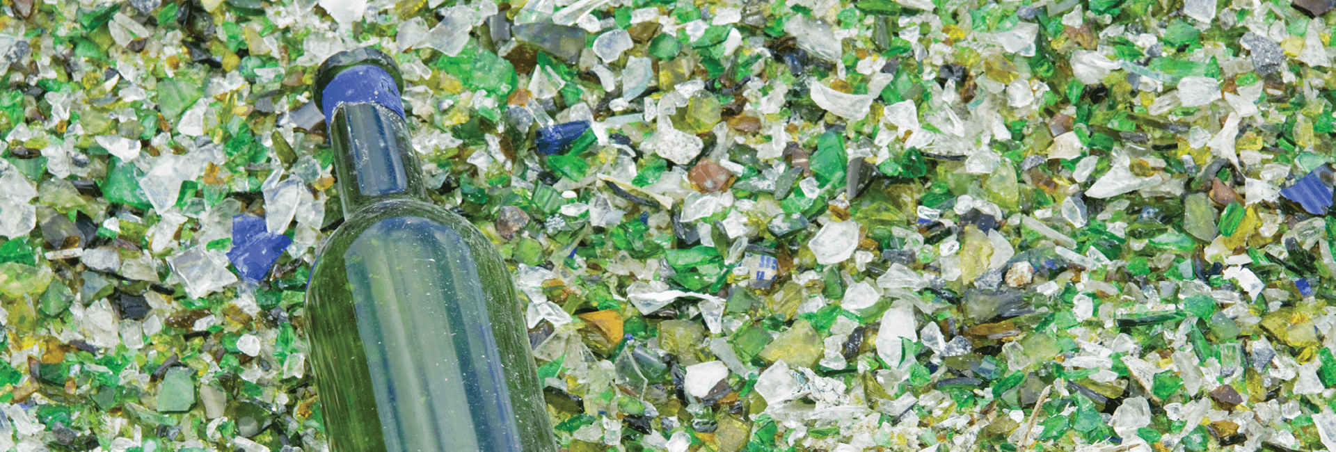 Crushed recycled glass and a green glass bottle